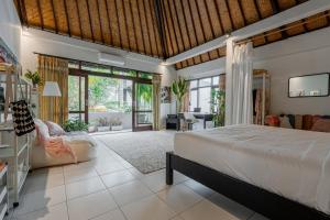 a bedroom with a bed and a living room at Pondok Alami Villas 5BR & Pool in Ubud
