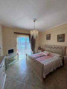 a bedroom with a large bed and a chandelier at Villa Kastri in Igoumenitsa