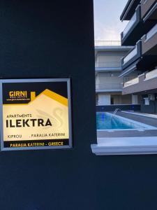 a sign on a wall next to a swimming pool at Apartman Velickovic in Paralia Katerinis