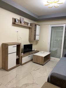 a living room with a tv and a table in it at Apartman Velickovic in Paralia Katerinis +2 photos