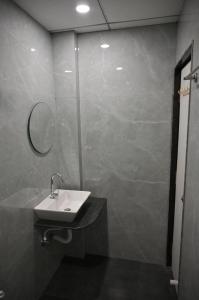 a bathroom with a sink and a mirror at Hotel Sai Vaibhav in Shirdi