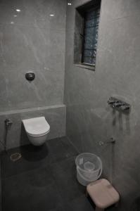 a bathroom with a toilet and a window at Hotel Sai Vaibhav in Shirdi