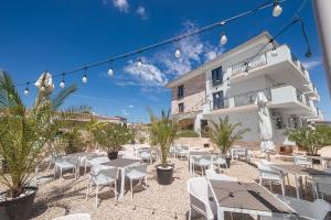 a patio with tables and chairs in front of a building at Escape Vama Veche in Vama Veche +48 photos