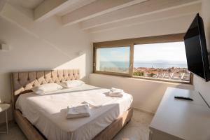 a bedroom with a bed with a large window at Villa Mare 3 - Private Pool, Sea View in Hanioti +36 photos