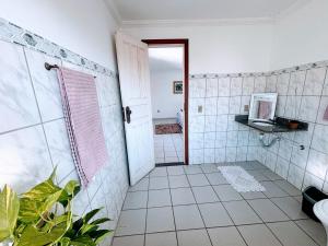 a bathroom with a white tiled shower and a door at Hostel onda azul in Serra +32 photos