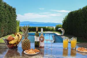 a table topped with glasses of wine and fruit at Villa Mare 3 - Private Pool, Sea View in Hanioti