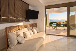 a living room with a couch and a view of a patio at Villa Mare 3 - Private Pool, Sea View in Hanioti