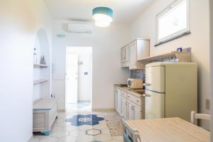 a kitchen with a refrigerator and a table at Agri resort La Dragonara in Bacoli