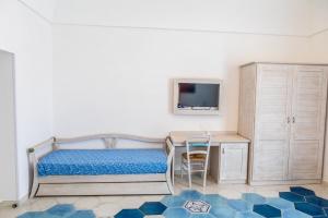 a bedroom with a bed and a desk and a tv at Agri resort La Dragonara in Bacoli