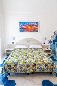 a bedroom with a bed with a colorful quilt at Agri resort La Dragonara in Bacoli