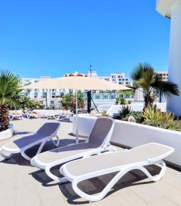 a group of chairs and an umbrella on a patio at Sanmarcos in Playa Paraiso