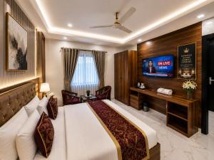 a hotel room with a bed and a flat screen tv at The Comfort Villa Manage By Bellamount Hotel Free Airport Pick Up & Drop in New Delhi