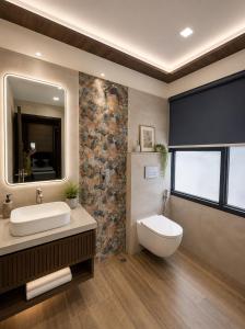 a bathroom with a toilet and a sink and a mirror at The Comfort Villa Manage By Bellamount Hotel Free Airport Pick Up & Drop in New Delhi