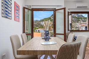 a dining room with a wooden table and chairs at Agio Porto Cervo in Liscia di Vacca