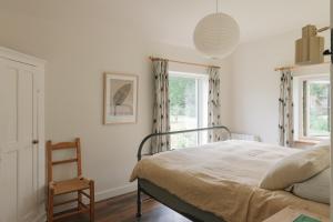a bedroom with a bed and a chair and a window at The Roost in Westport