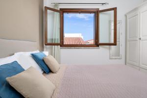 a bedroom with a bed and a window at Agio Porto Cervo in Liscia di Vacca