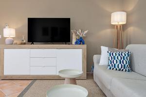a living room with a tv and a couch at Agio Porto Cervo in Liscia di Vacca +18 photos