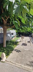 a park with benches and a tree with leaves at rev'hotel in Vias