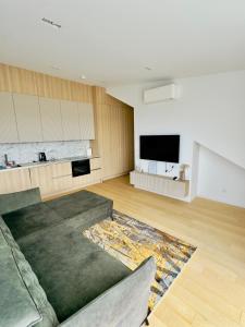 a living room with a couch and a flat screen tv at V7 Apartamentai Nidoje in Nida