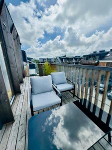two chairs and a table on a balcony with the sky at V7 Apartamentai Nidoje in Nida +1 photo