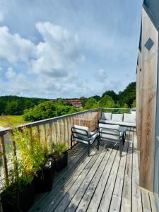 a wooden deck with two chairs and a table on it at V7 Apartamentai Nidoje in Nida