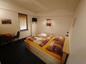 a bedroom with a bed in a room with a table at Riegrova Chata Kozákov in Semily