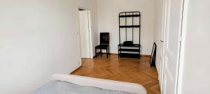 a white room with a bed and a wooden floor at Apartament na Granicy 5 in Cieszyn