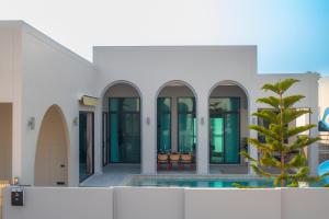 a building with a pool and a palm tree at April Pool Day Villa Cha-am in Cha Am +5 photos