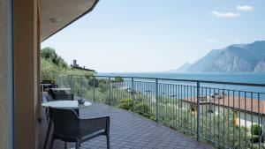 a balcony with a table and chairs and the ocean at Hotel Casa Marinella in Malcesine