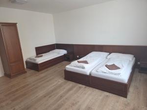 two beds in a room with wooden floors at Laguna ubytovanie 2 A in Trenčín