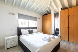 a bedroom with a large white bed and wooden cabinets at Gaia - 4 Bedroom House in Larnaca in Larnaca +32 photos