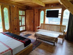 ein Schlafzimmer mit einem Bett, einer Bank und einem Fernseher in der Unterkunft Him cottage in Gushaini