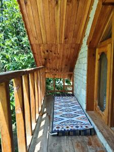 eine hölzerne Veranda mit einer Matte auf einem Deck in der Unterkunft Him cottage in Gushaini