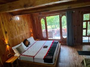 ein Schlafzimmer mit einem Bett in einem Holzzimmer in der Unterkunft Him cottage in Gushaini
