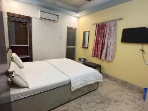 a bedroom with a bed and a flat screen tv at Hotel Nalanda City in Nalanda