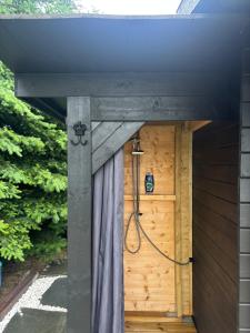 a shower in a building with a wooden door at Simple Lakeside Anex - By the Water's Edge in Vossevangen
