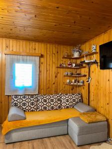 a bed in a room with wooden walls and a window at Chalet Rustique-Covasna in Covasna
