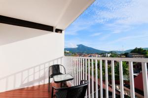 a balcony with two chairs and a view of the mountains at Al Barra Syariah Hotel in Bukittinggi