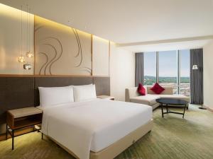 a hotel room with a bed and a couch at Radisson Golf & Convention Center Batam in Batam Center