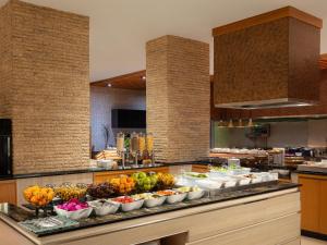 a buffet line with bowls of fruits and vegetables at Radisson Golf & Convention Center Batam in Batam Center