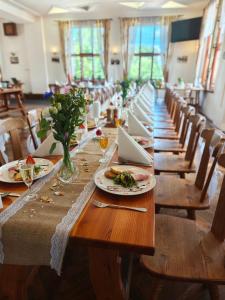 a long table with plates of food and flowers on it at Riegrova Chata Kozákov in Semily