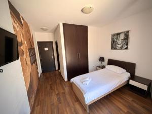 ein Schlafzimmer mit einem weißen Bett und Holzböden in der Unterkunft Hotel Storia in Čapljina