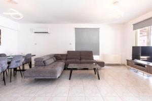 a living room with a couch and a table and a tv at Gaia - 4 Bedroom House in Larnaca in Larnaca