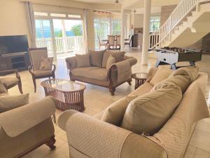 a living room with couches and tables and a television at Bord Mer House in Glacis