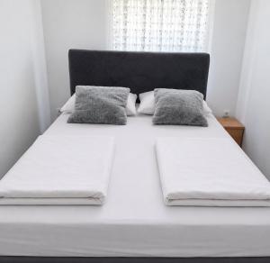 a large white bed with two pillows on it at Sofija 1 in Jesenice