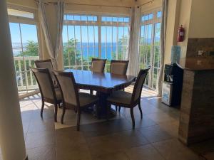 a dining room table and chairs with a view of the ocean at Bord Mer House in Glacis