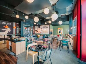 a restaurant with tables and chairs in a room at ibis Styles Lens Centre Gare in Lens