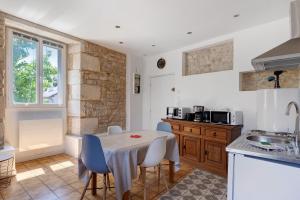 a kitchen with a table and chairs in a room at Studio 5 - 3 min du Futuroscope in Chasseneuil-du-Poitou