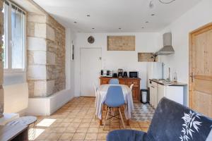 a kitchen and dining room with a table and chairs at Studio 5 - 3 min du Futuroscope in Chasseneuil-du-Poitou +11 photos