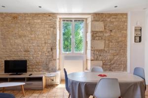 a living room with a table and a tv at Studio 5 - 3 min du Futuroscope in Chasseneuil-du-Poitou